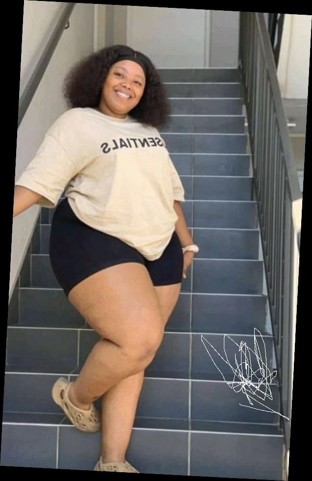 Ideal summer outfit for plus size women 11 A plus size woman wearing Tan "ESSENTIALS" oversized t-shirt Black high-waist bike shorts Tan foam runners (Yeezy style) Black headband White scrunchie