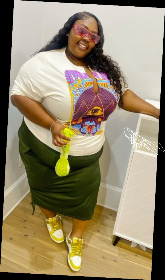 Right here are some pretty much affordable outfits for every plus size queen 9 A plus size woman wearing White graphic t-shirt with purple and orange "eye" design Olive green ruched midi skirt Yellow and white Nike Dunk sneakers Pink transparent sunglasses Silver necklace