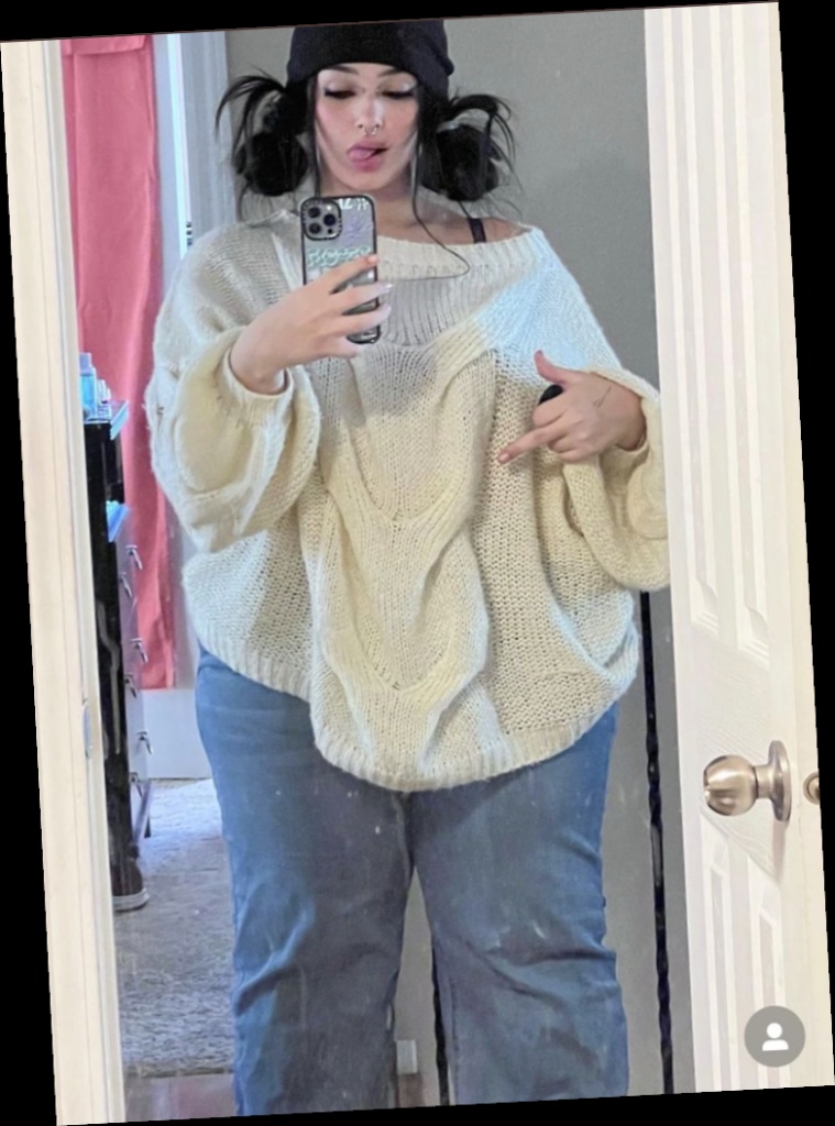 Ideal summer outfit for plus size women 6 A plus size woman wearing Cream oversized cable-knit sweater Light wash wide-leg jeans Black beanie Silver nose ring