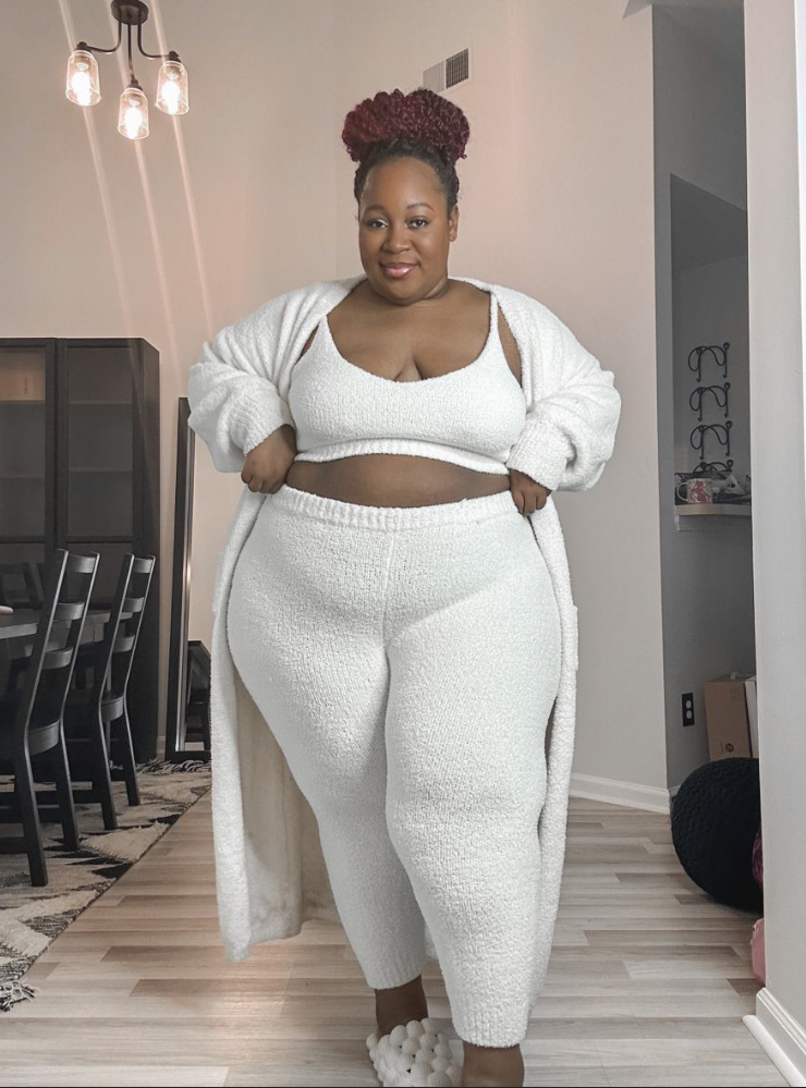 A plus size woman wearing Off-white fuzzy knit bouclé cropped cami top
Matching off-white high-waisted fuzzy knit lounge leggings
Matching off-white long open-front fuzzy knit cardigan robe
Cream textured cloud slide slippers

