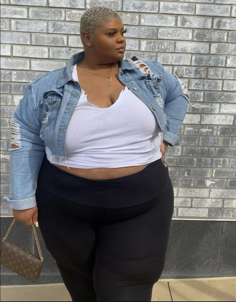 A plus size woman wearing White ribbed v-neck camisole crop top with a raw hem

Distressed light-wash denim jacket with ripped sleeve details

High-waisted black activewear leggings with a thick waistband

Monogram canvas mini shoulder bag with a gold chain strap

Gold nameplate pendant necklace