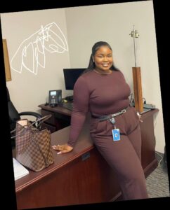 A Plus size woman in a monochrome plum workwear outfit.
