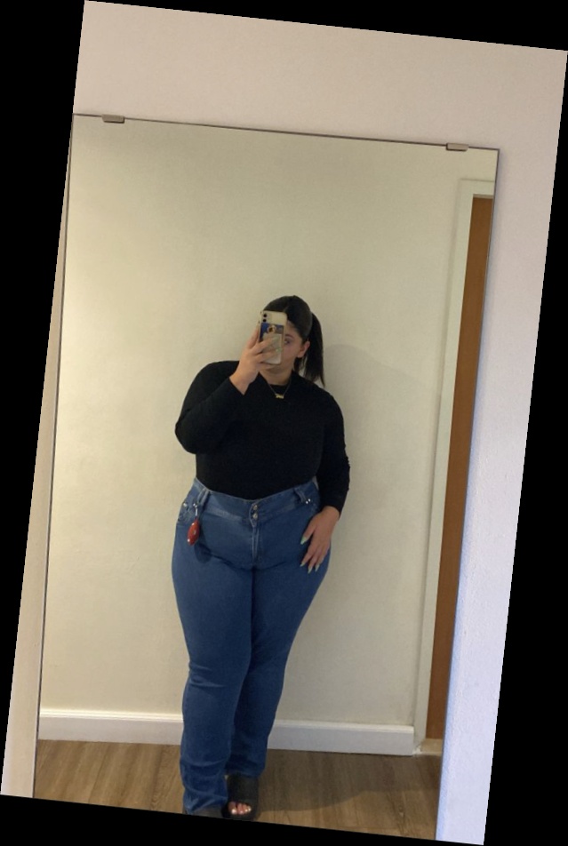 For the baddie girlies, here are some ways to eat up that baddie look 6 A plus size woman wearing Black long sleeve crewneck top Blue straight leg jeans Black slides Gold chain necklace