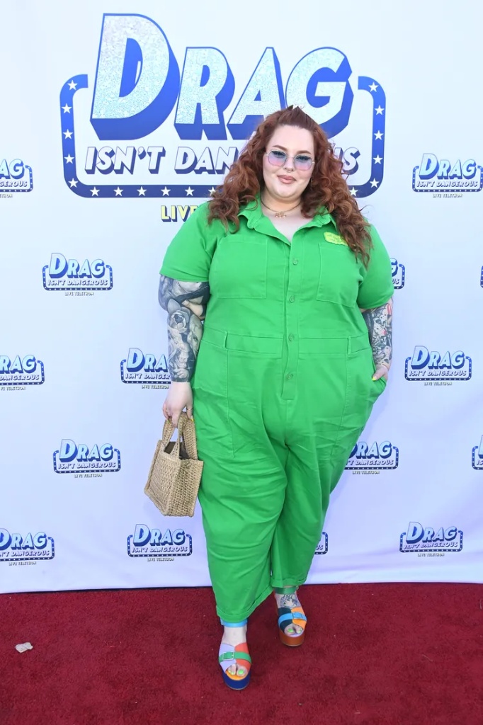 Ideal summer outfit for plus size women 3 A plussize woman wearing Bright green short-sleeve utility jumpsuit Multi-colored platform block-heel sandals Woven straw handbag Blue-tinted aviator sunglasses Gold "name" necklace