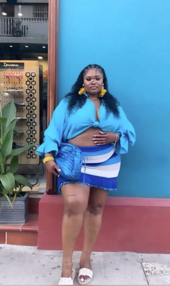 Beach Queen Energy: Stylish Outfits for Plus Size Women by the Sea 2 A plus size woman wearing Bright blue long-sleeve tie-front crop shirt with ruffled cuffs
Blue, white, and gray striped ribbed knit mini skirt
Metallic royal blue quilted puffer shoulder bag
Oversized yellow fringe tassel earrings
Chunky yellow bangle bracelet
White textured slide sandals
Gold ankle bracelet