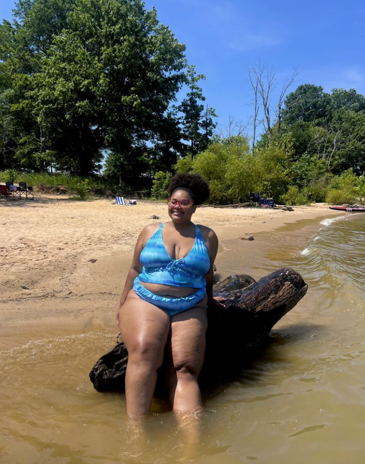 Beach Queen Energy: Stylish Outfits for Plus Size Women by the Sea 7 A plus size woman wearing Blue and white tie-dye watercolor print halter tankini top with drawstring front
Matching blue tie-dye bikini bottoms with a ruffled waistband
Pinkish-red translucent square-frame eyeglasses