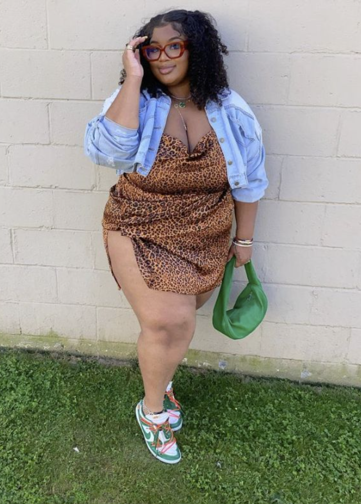 After Dark Glow: Baddie Night Out Outfits for Plus Size Women 4 A plus size woman wearing Satin cowl-neck leopard print mini dress with a side slit
Light-wash distressed denim jacket
Green leather slouchy crescent shoulder bag
Green and white leather low-top sneakers with orange contrast laces
Tortoiseshell square-frame glasses
Gold chain anklet