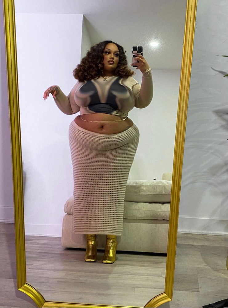 After Dark Glow: Baddie Night Out Outfits for Plus Size Women 5 A plus size woman wearing Long-sleeve sheer mesh crop top with an abstract body graphic print
Beige open-knit crochet maxi skirt
Metallic gold square-toe ankle boots
Dainty gold waist chain