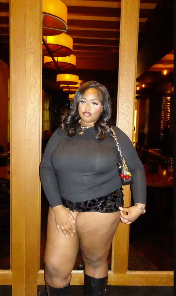 After Dark Glow: Baddie Night Out Outfits for Plus Size Women 10 A plus size woman wearing Black long-sleeve crewneck top
Black high-waisted sequined mini shorts
Black leather knee-high boots
Black leather shoulder bag with double cherry bag charms
Gold chain link necklace with a star pendant
Silver chain link bracelet