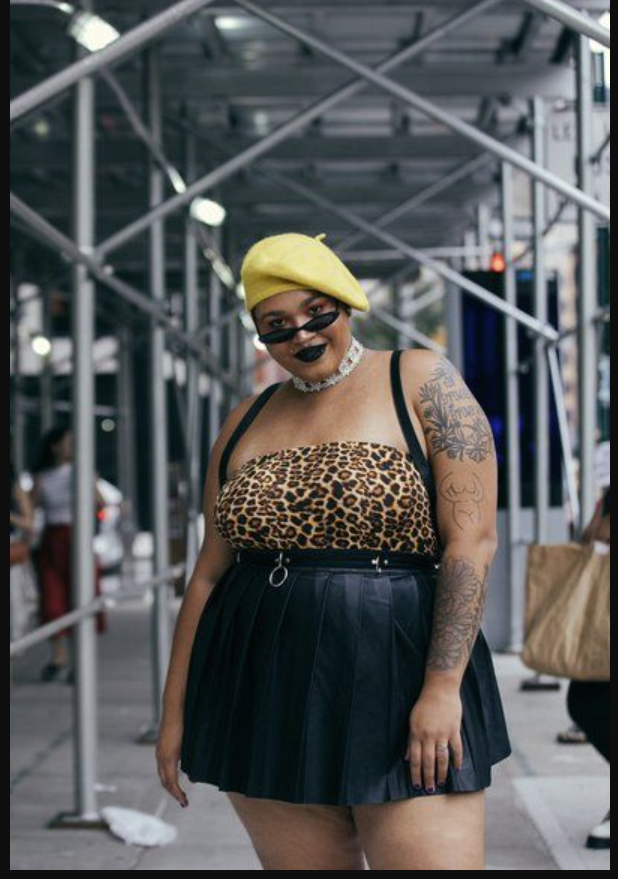Skirt Season Forever: Flattering Skirt Outfits for Plus Size Women 11 A plus size woman wearing Leopard print strapless tube top
Black pleated mini skirt
Yellow beret
Black cat-eye sunglasses
White lace choker
Silver belt with rings