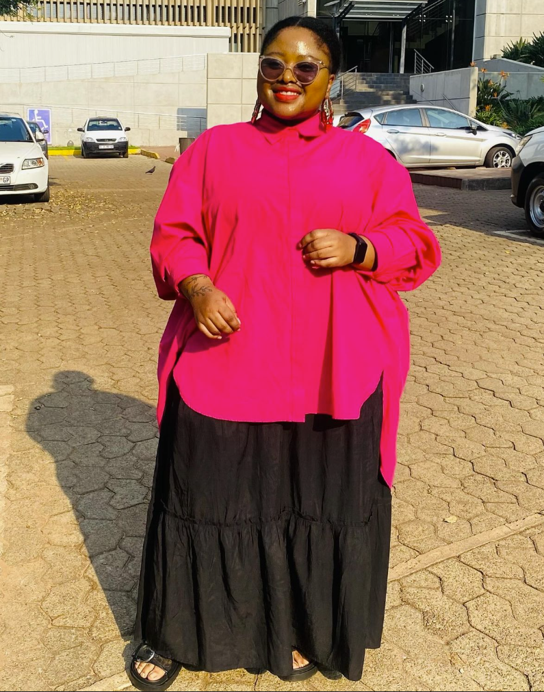 Skirt Season Forever: Flattering Skirt Outfits for Plus Size Women 5 A plus size woman wearing Hot pink oversized button-up shirt
Black tiered maxi skirt
Brown sunglasses
Red dangling earrings
Black slide sandals