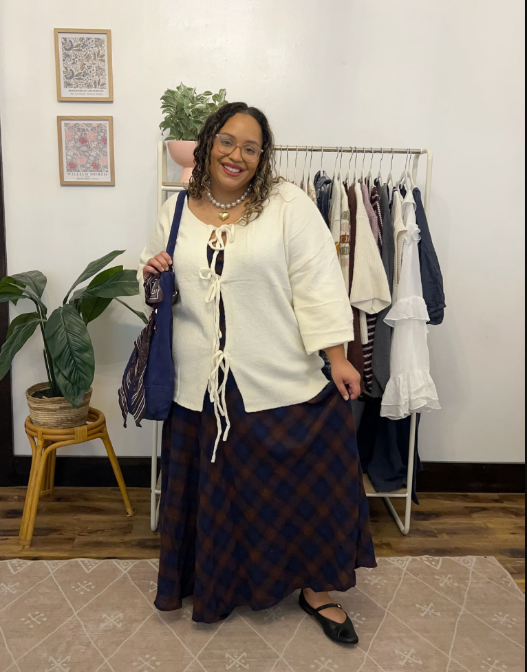 A plus size woman wearing White lace-up knit cardigan Brown and blue plaid maxi skirt Pearl necklace Blue tote bag Black Mary Jane flats Glasses