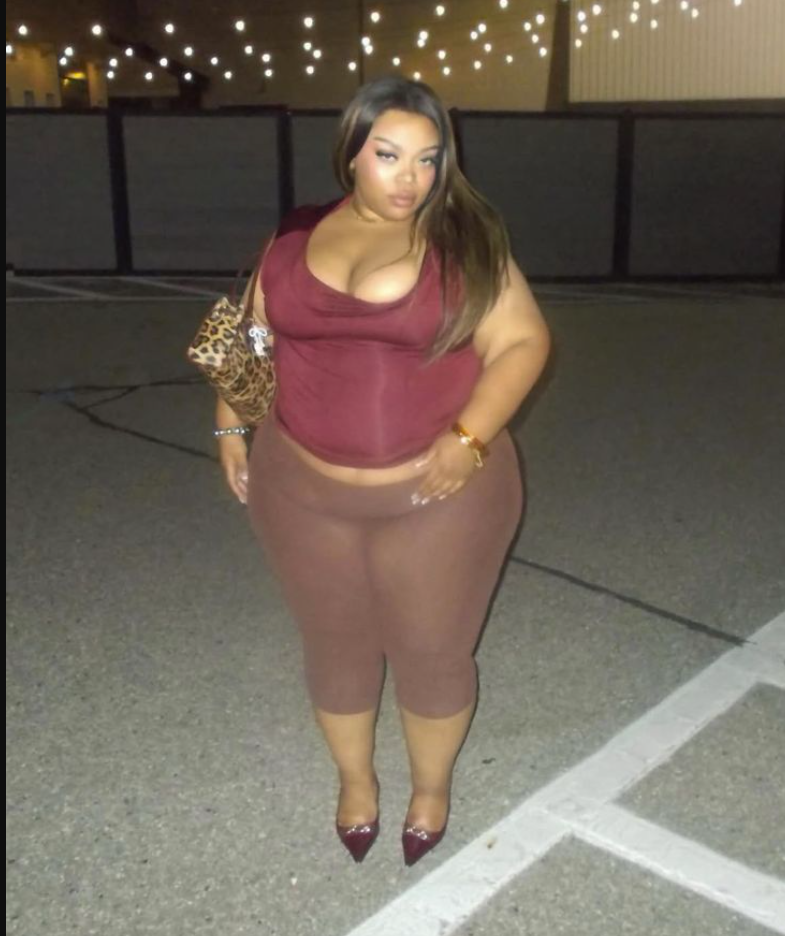 A plus size woman wearing Maroon ruched sleeveless crop top
Brown sheer high-waisted leggings
Leopard print handbag
Burgundy pointed-toe heels
Gold bracelet