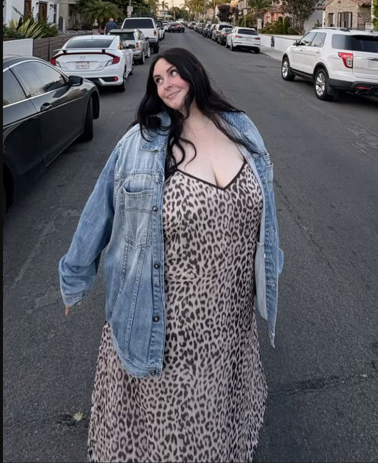 A plus size woman wearing Leopard print slip dress Light blue denim jacket Thin necklace